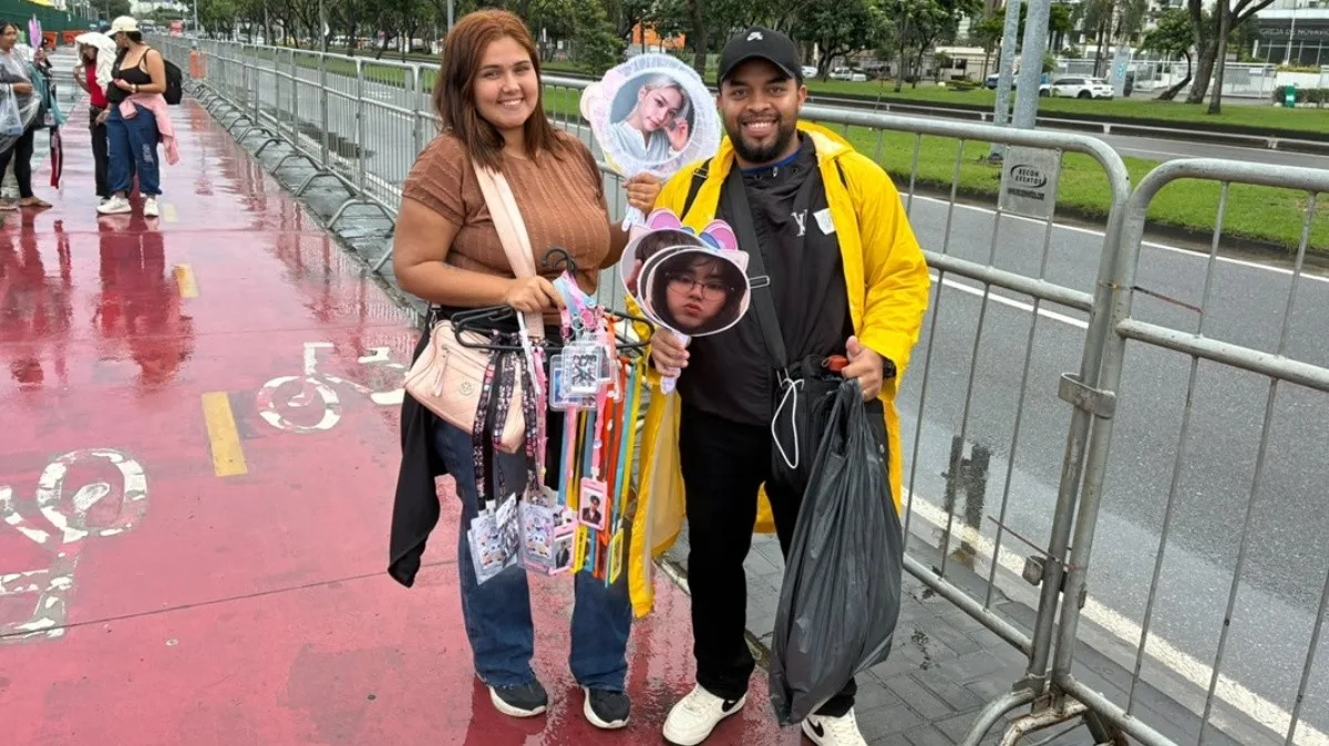 Vendedores oferecem leques e fotos de integrantes do Stray Kids na fila